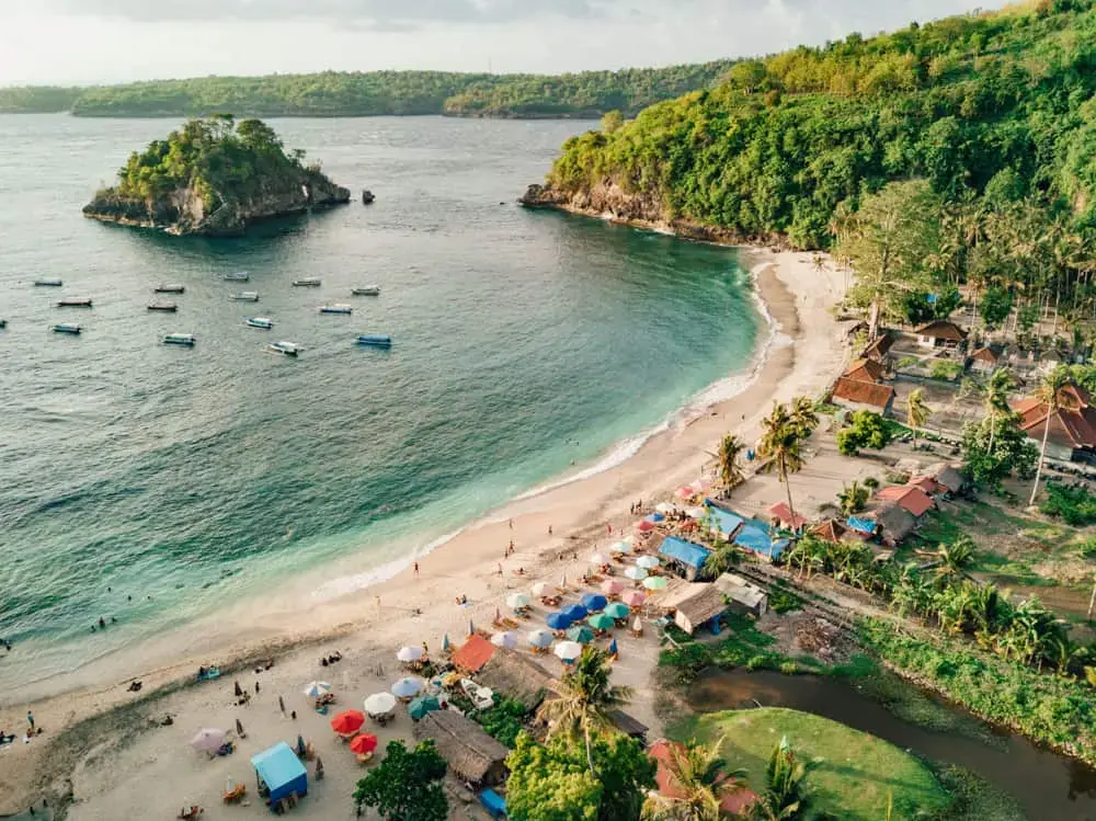 Beautiful sunset view over the ocean and palm trees at Crystal Bay Beach in Nusa Penida